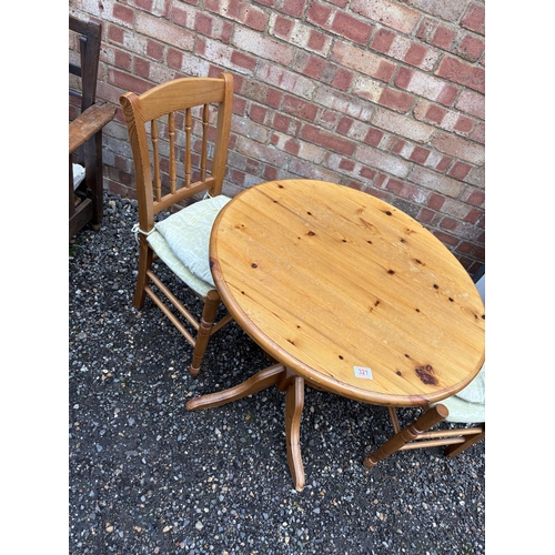 317 - A circular pine table with two chairs 77cm diameter
