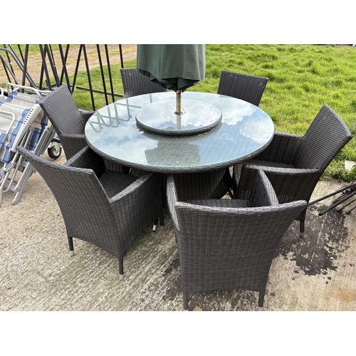 481 - A  modern black ratan garden table together with six chairs,  lazy Susan and parasol 142cm diameter