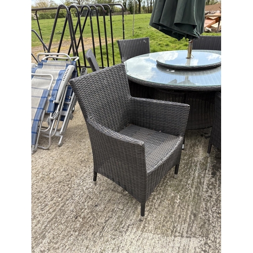 481 - A  modern black ratan garden table together with six chairs,  lazy Susan and parasol 142cm diameter