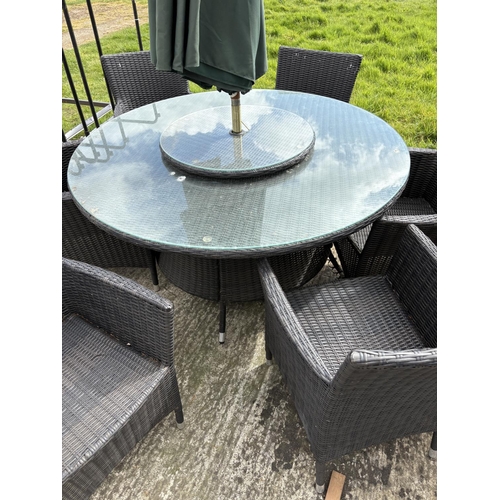 481 - A  modern black ratan garden table together with six chairs,  lazy Susan and parasol 142cm diameter