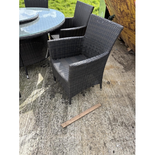 481 - A  modern black ratan garden table together with six chairs,  lazy Susan and parasol 142cm diameter