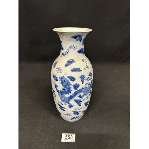 558 - Oriental blue and white dragon vase, height 28cms