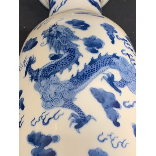 558 - Oriental blue and white dragon vase, height 28cms