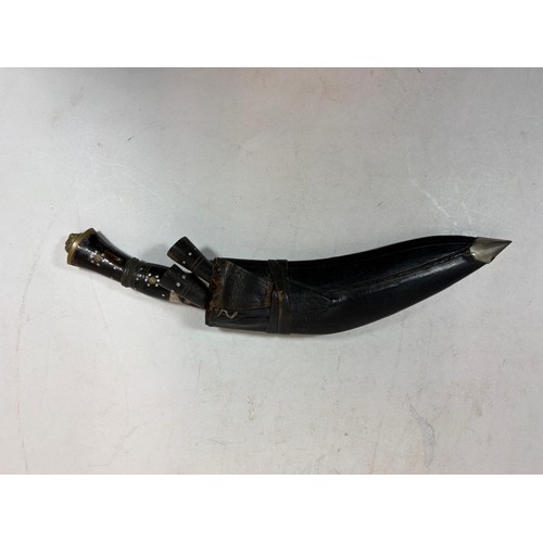 138 - A 20thC Indian Kukri, a principal knife, with a lion's head terminal, two smaller knives, in a toole... 