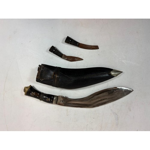 138 - A 20thC Indian Kukri, a principal knife, with a lion's head terminal, two smaller knives, in a toole... 