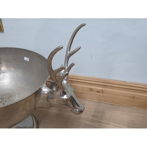 21 - A very large antique style polished metal 24 bottle champagne cooler in the form of a footed bowl, w... 