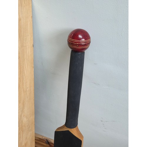 47 - A novelty chalk board in the form of traditional cricket bat with cricket ball surmount. Presented i... 