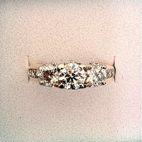 49 - A 14ct diamond set dress ring.Centrally set with a round brilliant cut diamond flanked by two furthe... 