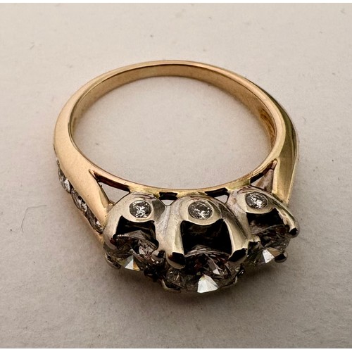 49 - A 14ct diamond set dress ring.Centrally set with a round brilliant cut diamond flanked by two furthe... 
