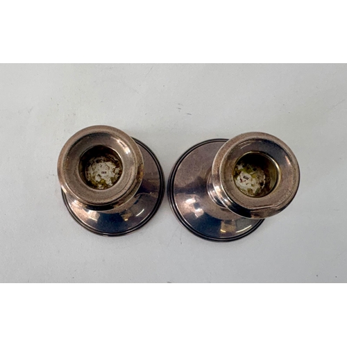112 - A pair of Georgian style weighted squat silver candlesticksR&D Birmingham 1971(2)