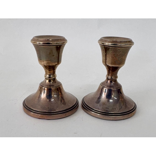112 - A pair of Georgian style weighted squat silver candlesticksR&D Birmingham 1971(2)