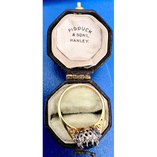 115 - A Sapphire and diamond cluster dress ring on 18ct white and yellow gold.The oval cut sapphire aprox ... 