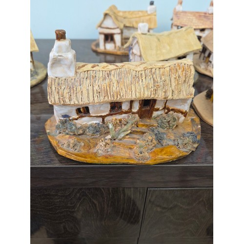 A collection of pottery house and mushroom sculptures from various craft shops