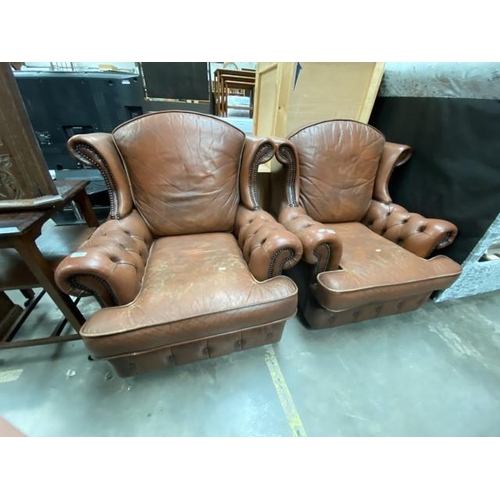 Pair of tan leather wing armchairs (leather as found) (85w cm)