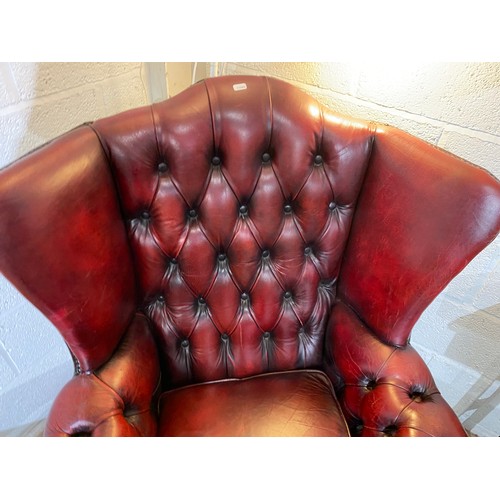 92 - Oxblood leather button back Chesterfield wing armchair (90W cm) & footstool