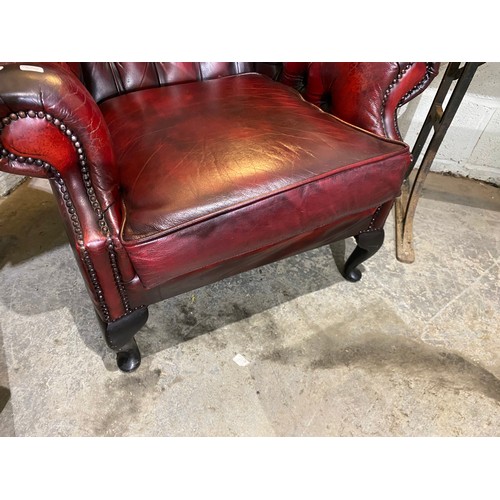 92 - Oxblood leather button back Chesterfield wing armchair (90W cm) & footstool