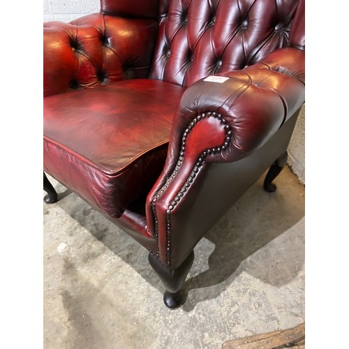 92 - Oxblood leather button back Chesterfield wing armchair (90W cm) & footstool