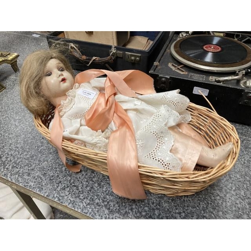 264 - Antique Belgian doll in basket crib (one leg as seen)