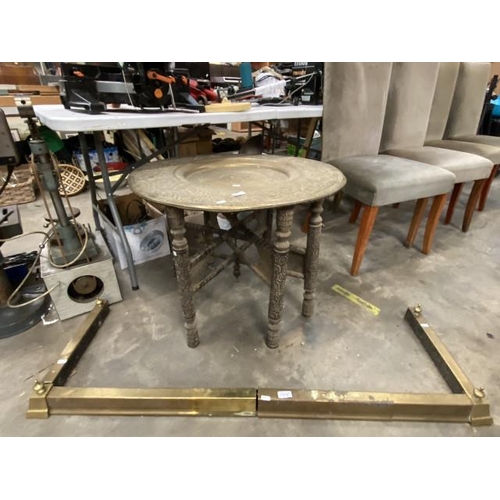 184 - Middle Eastern copper table on a folding base 56H 76cm diameter and an extending brass fender 125W