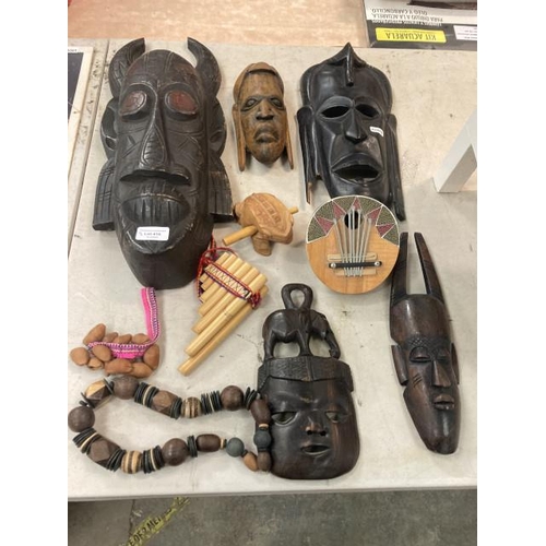 416 - Assorted wooden tribal artifacts including head carvings, musical instruments, beads etc