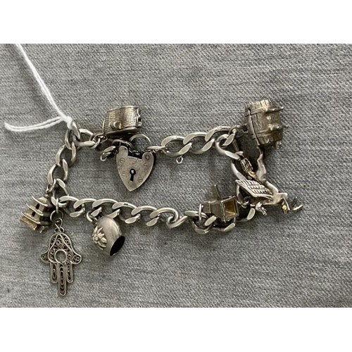 391 - Silver charm bracelet with 7 charms 43g