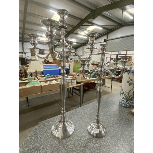 148 - Two stainless steel candelabras 81H & 63H