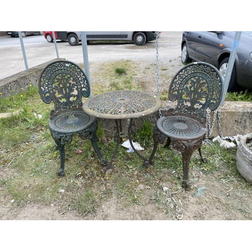 592 - 2 cast garden chairs and table 56H 65cm diameter