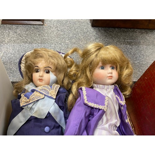 557 - A collection of clothed bisque headed dolls, assorted dolls clothing etc