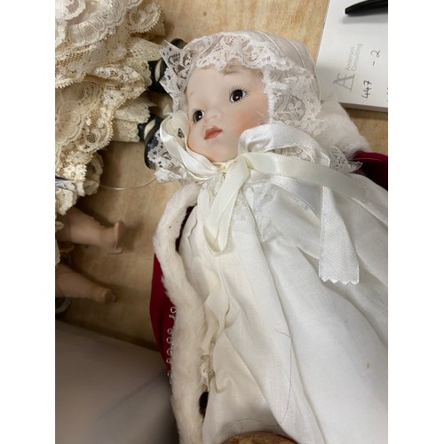 557 - A collection of clothed bisque headed dolls, assorted dolls clothing etc