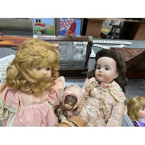 557 - A collection of clothed bisque headed dolls, assorted dolls clothing etc