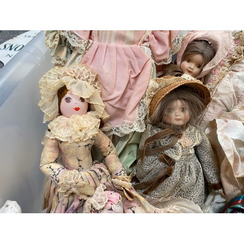 557 - A collection of clothed bisque headed dolls, assorted dolls clothing etc