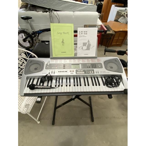 80 - Casio LK-55 keyboard with power lead, floor stand , 2 books & music stand & microphone with plug