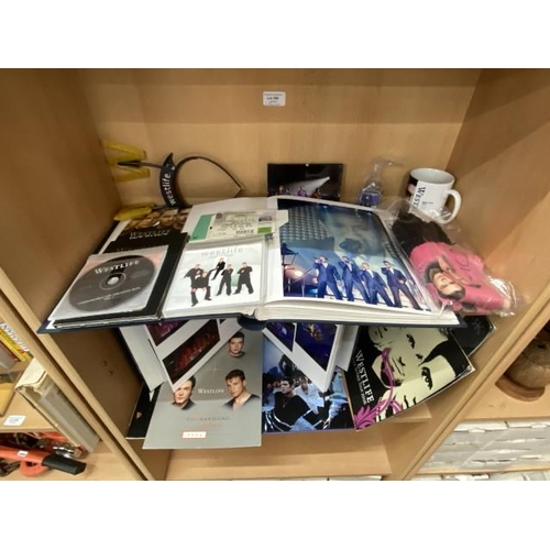 299 - 2 shelves of Westlife memorabilia including picture album, tour magazines/programmes, CDs, tickets, ... 