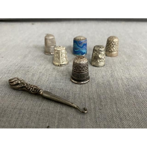 296 - Five silver thimbles, one Dorcas thimble and button hook.