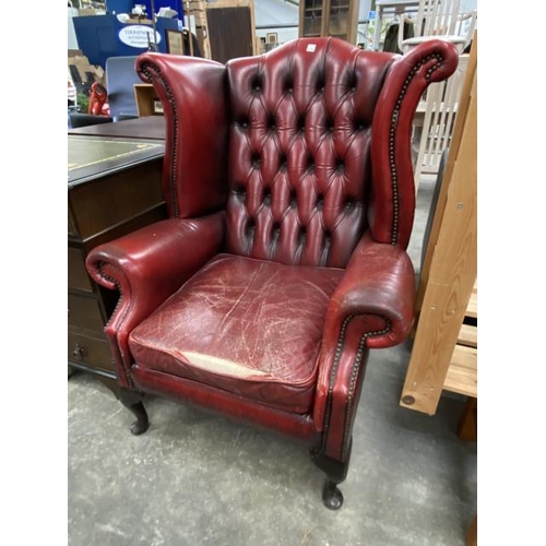 161 - Ox blood leather Chesterfield wing armchair 84W (damage to leather, sold as seen)