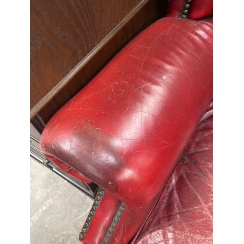 161 - Ox blood leather Chesterfield wing armchair 84W (damage to leather, sold as seen)