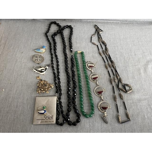 332 - Box of costume jewellery including Jade beads, Mid century style bracelet, Celtic brooch etc.