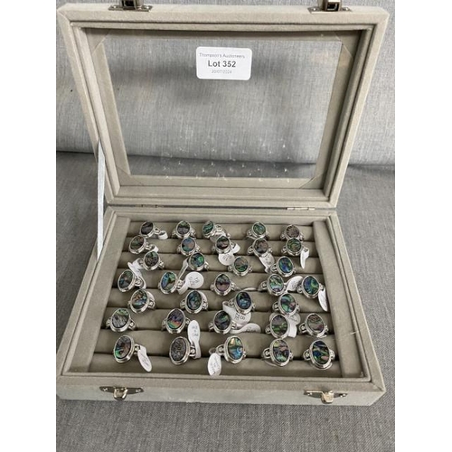 352 - 33 costume paua shell rings in display case, NEW (sizes N, Q & R)