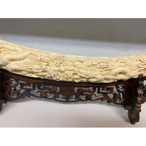 329 - Reproduction resin carved elephant tusk on stand 53W