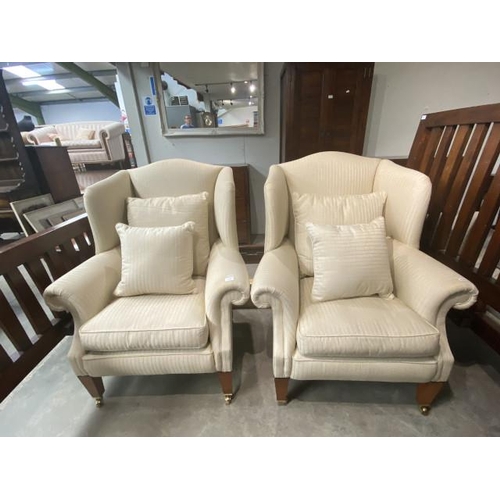 65 - 2 Laura Ashley cream upholstered wing armchairs with brass castors