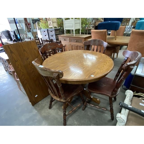 211 - Oak extending dining table with one leaf 76H  107-153 diameter and 4 chairs