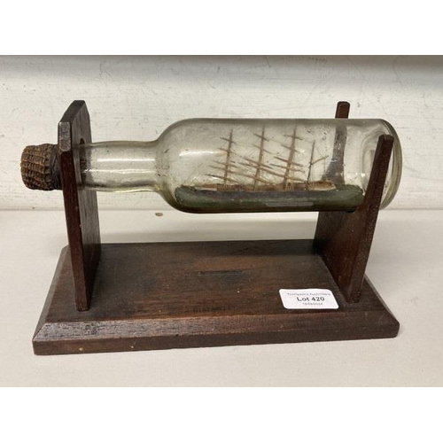 420 - Early 20th century model sailing ship in a bottle supported on an oak stand (stamped S.C. Staveley) ... 