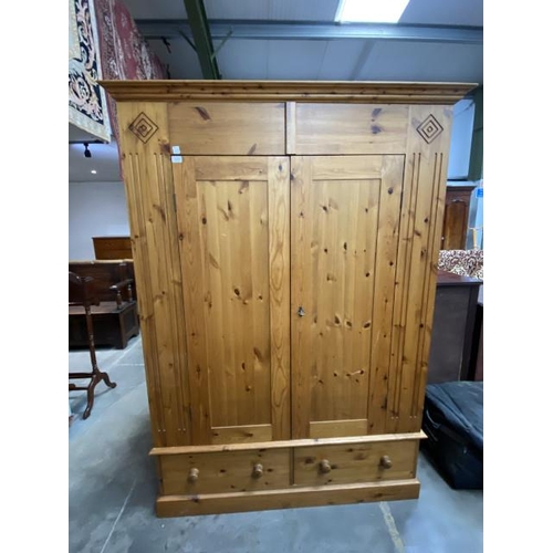 92 - Waxed pine two door wardrobe with two drawers to the underneath (hanging rail to the interior) and o... 