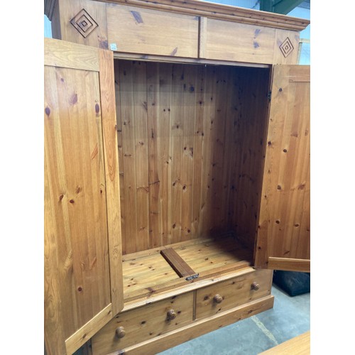 92 - Waxed pine two door wardrobe with two drawers to the underneath (hanging rail to the interior) and o... 