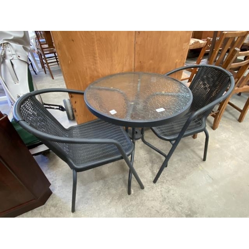 138 - Glass topped garden table 69H 60cm diameter and 2 chairs