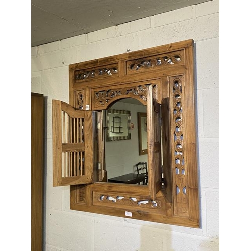 111 - Balinese teak framed fretwork wall mirror concealed by two doors 88 x 79cm