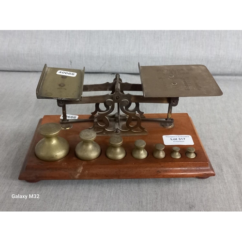 317 - Brass postal scales with all 7 weights.