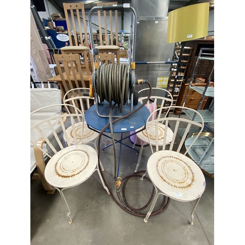 103 - French metal garden table 73H 60cm diameter, 4 chairs and hosepipe with reel