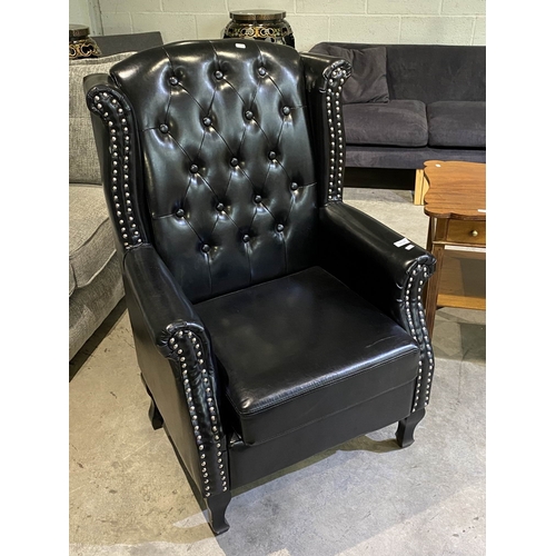 130 - Black faux leather button back Chesterfield wing armchair 112H x 75W
