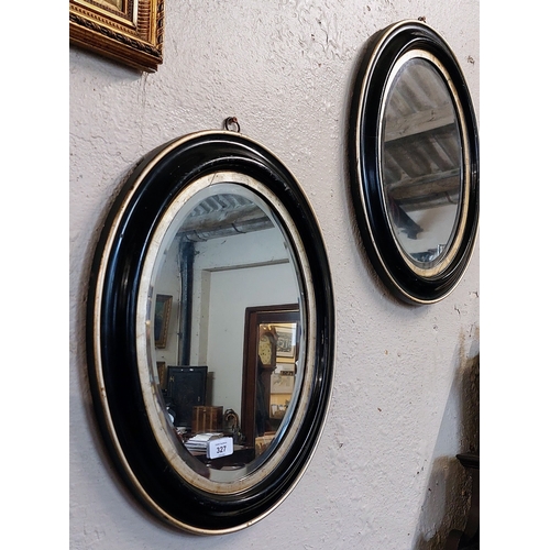 327 - Pair of Ebonised and Gilt Oval Bevelled Mirrors - C. 52cm H x 42cm W